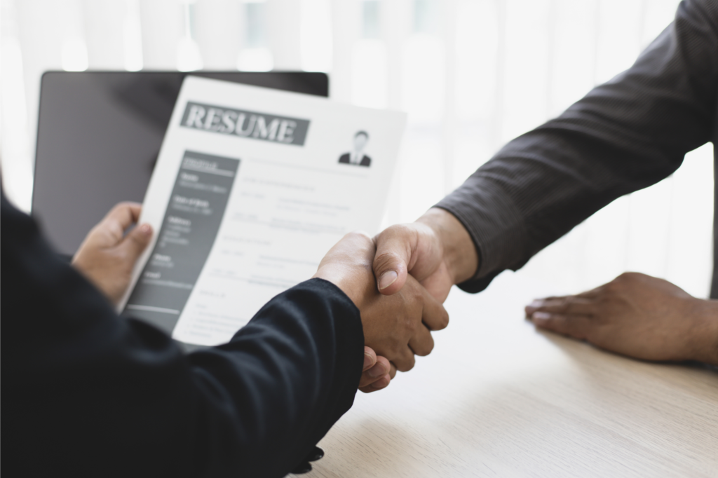 Two people shaking hands during a job interview.